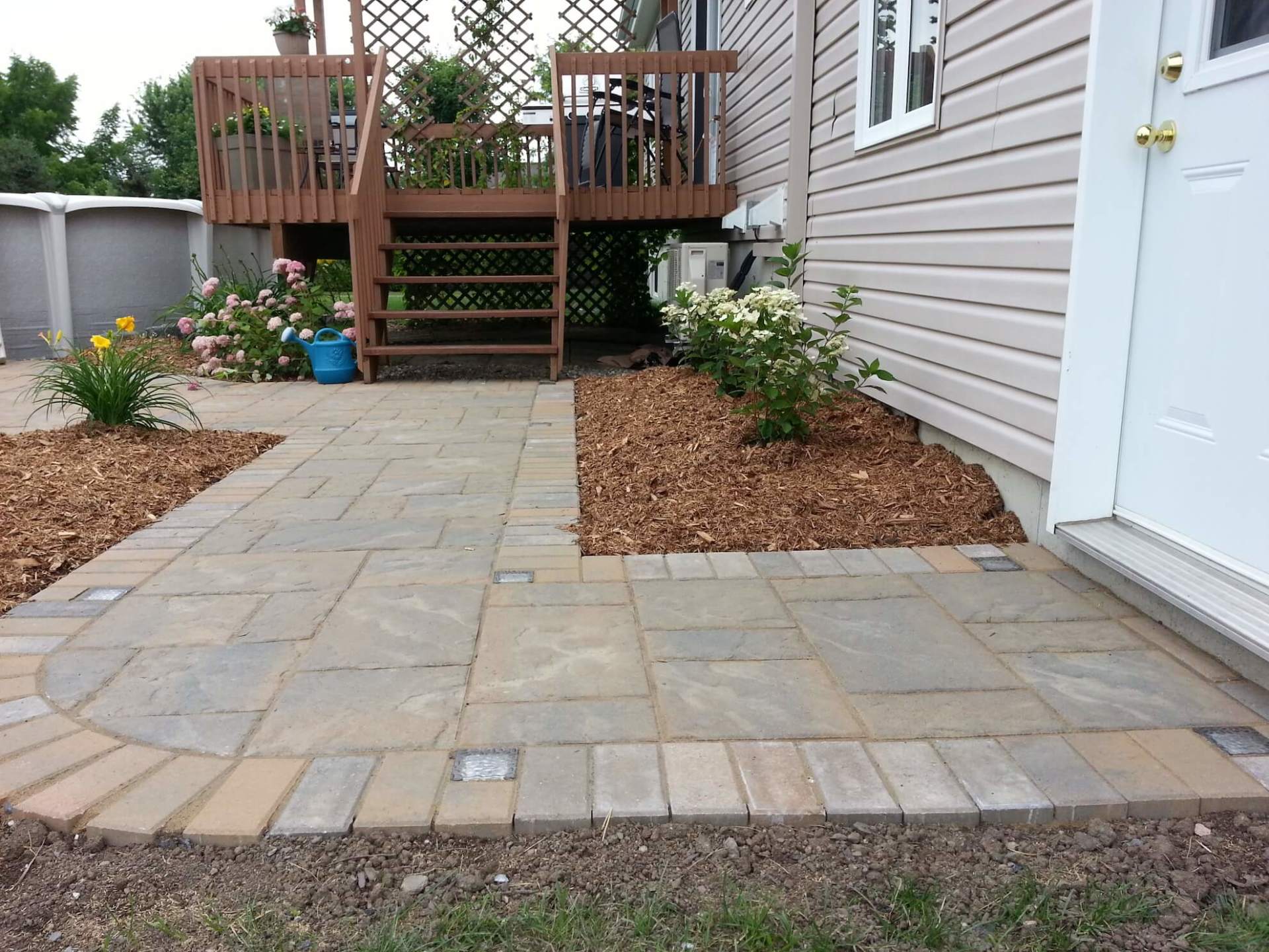 Un patio devant une maison avec une terrasse