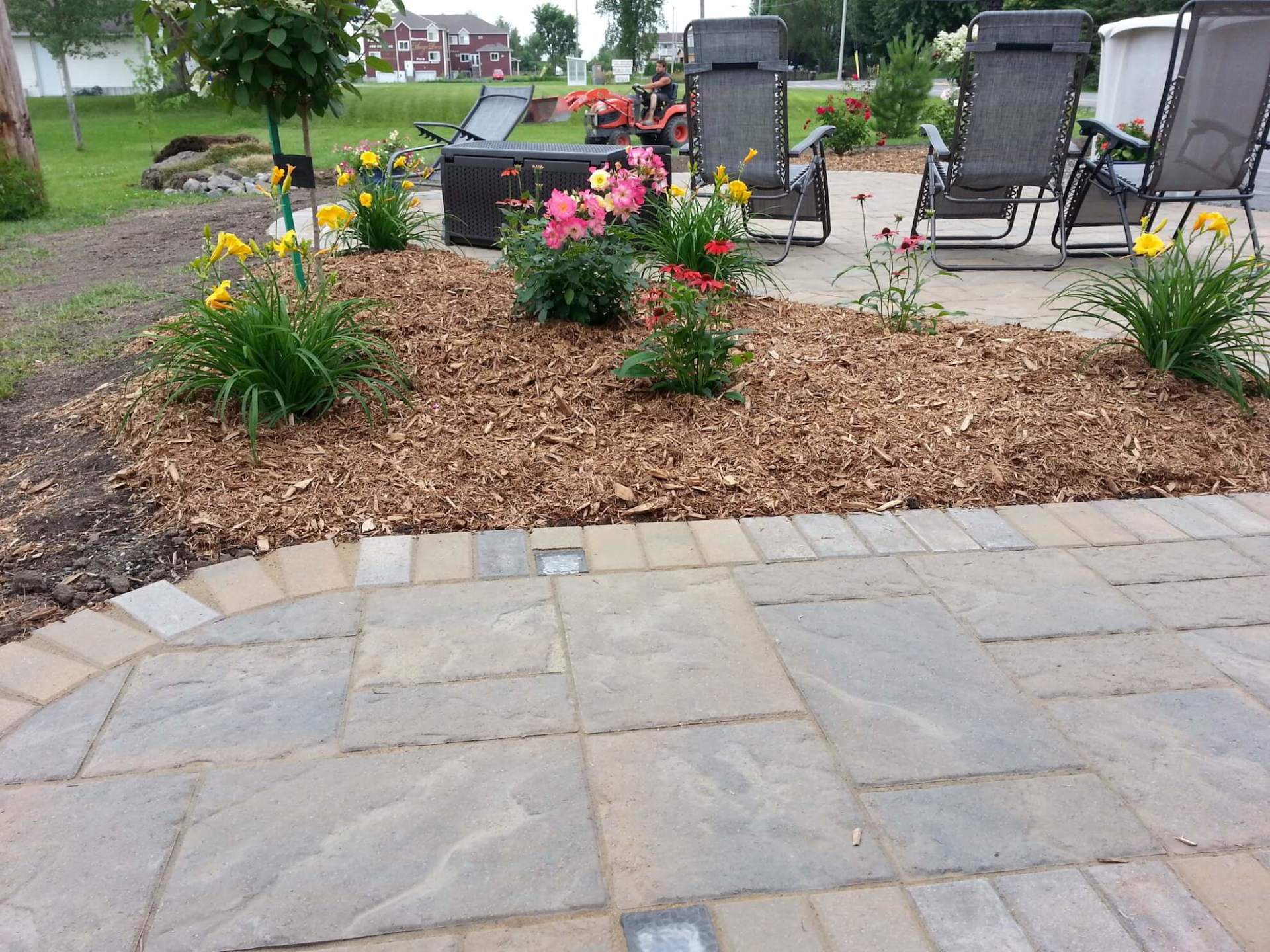 Un patio avec des chaises et des fleurs en arrière-plan