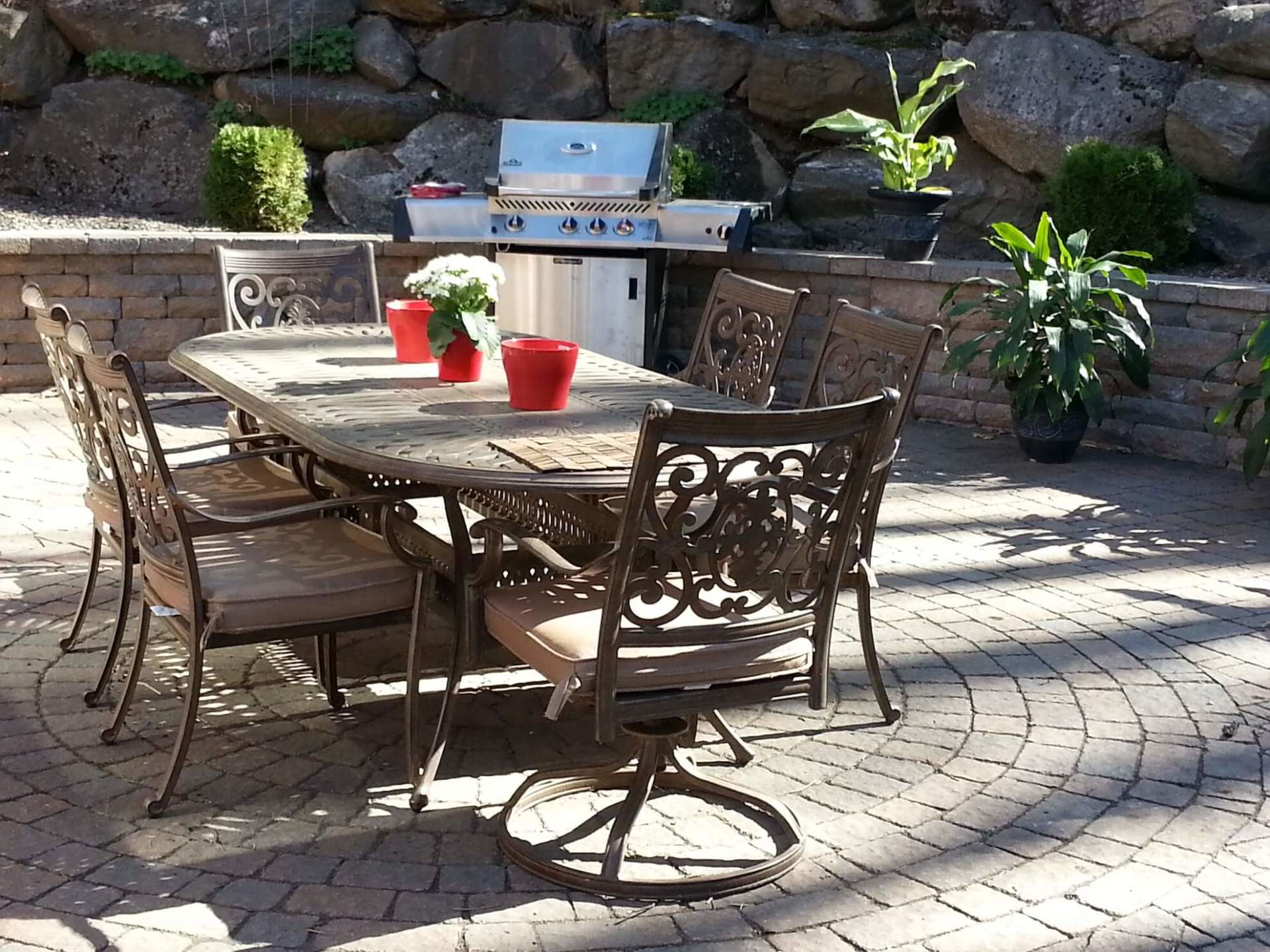 Un patio avec une table, des chaises et un barbecue