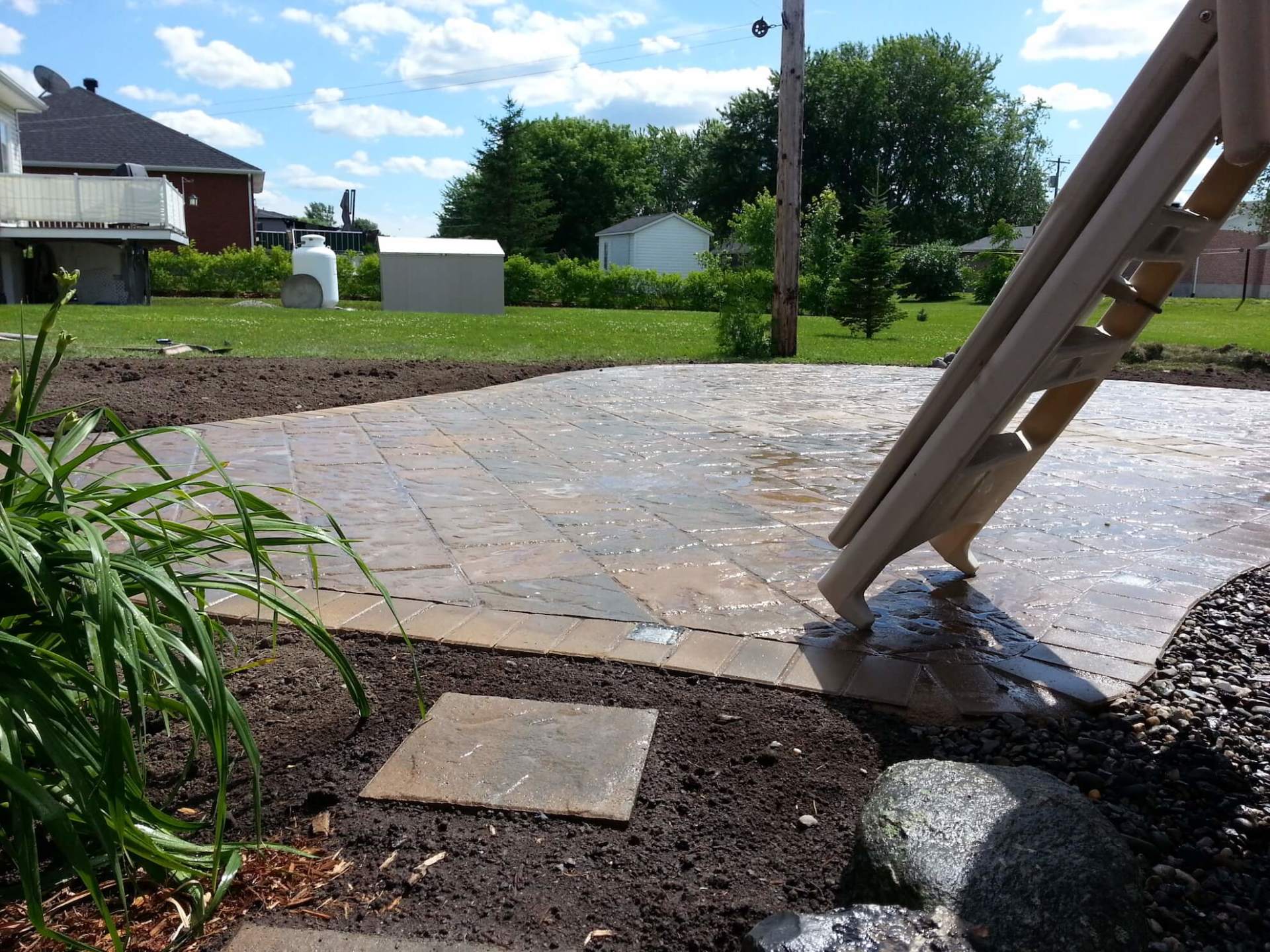 Un patio avec un escalier menant à une maison en arrière-plan