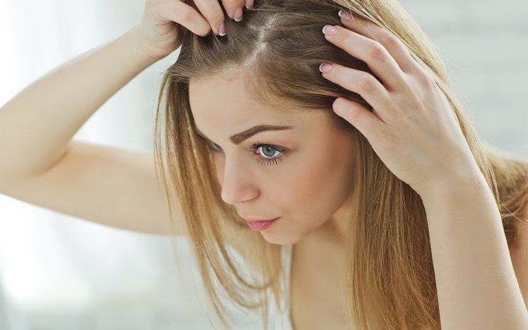 Uma mulher está olhando seu cabelo no espelho.
