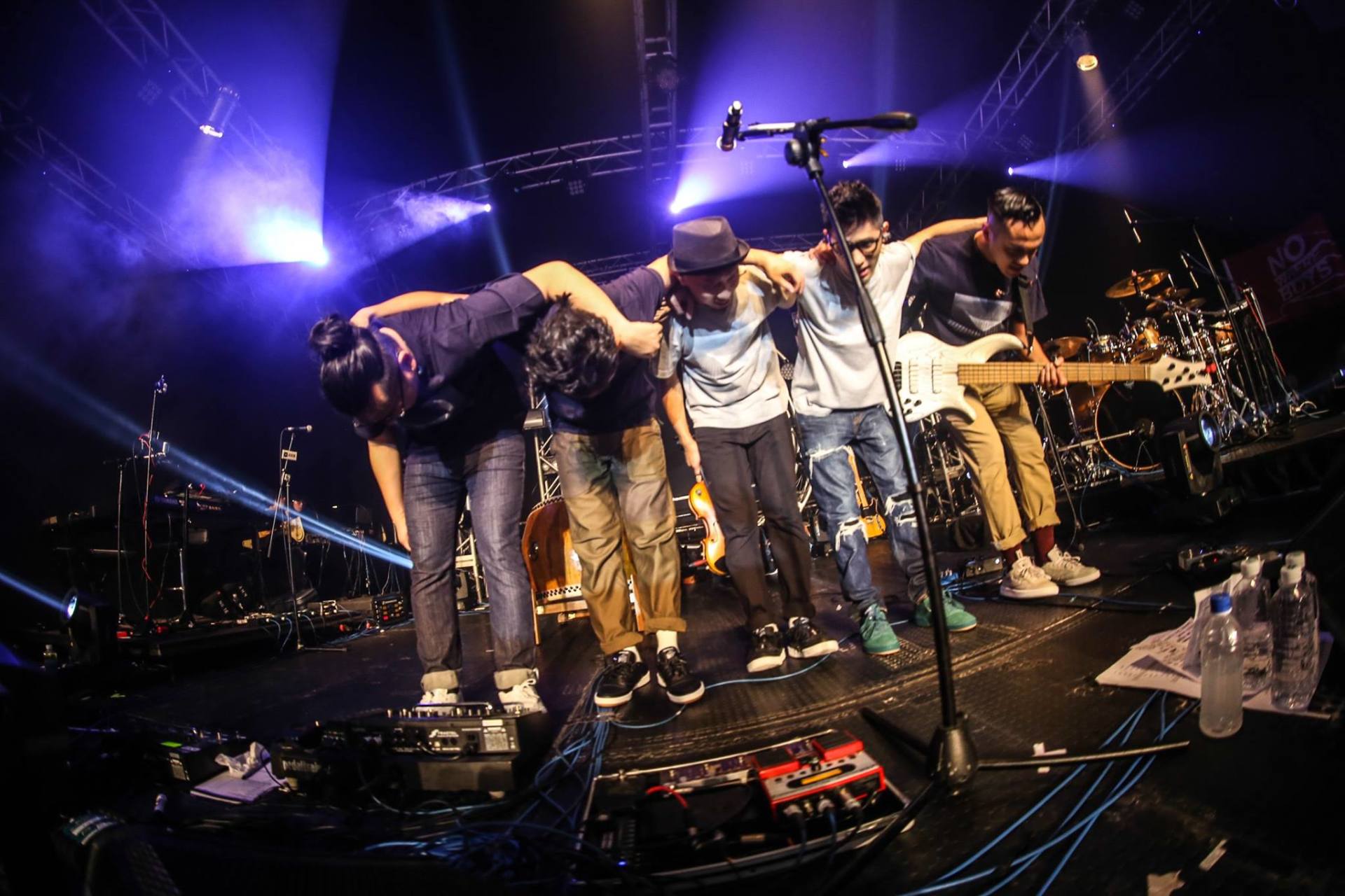 A group of people are standing on a stage in front of a microphone.