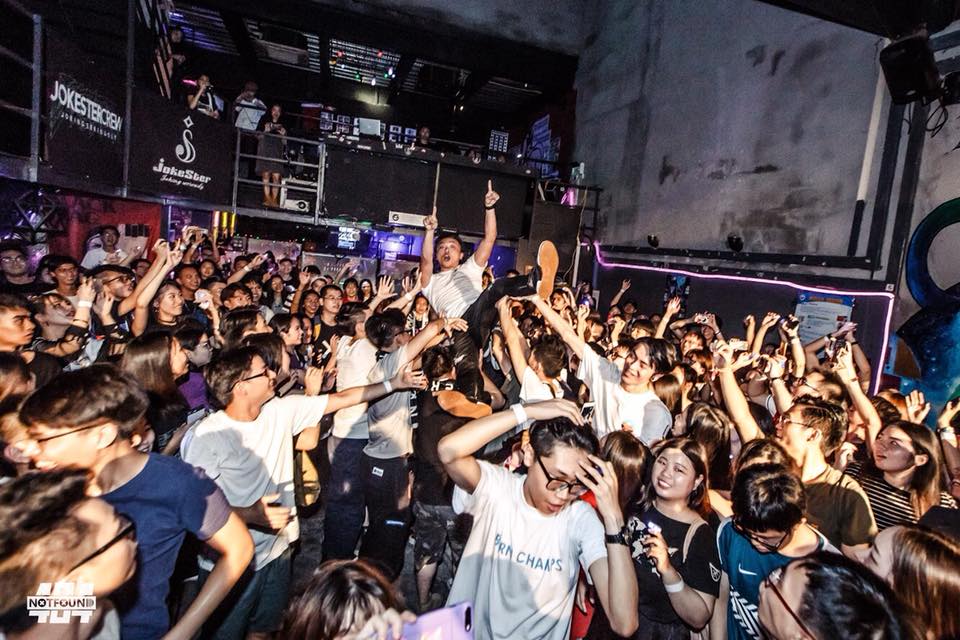 A large crowd of people are dancing in a club.