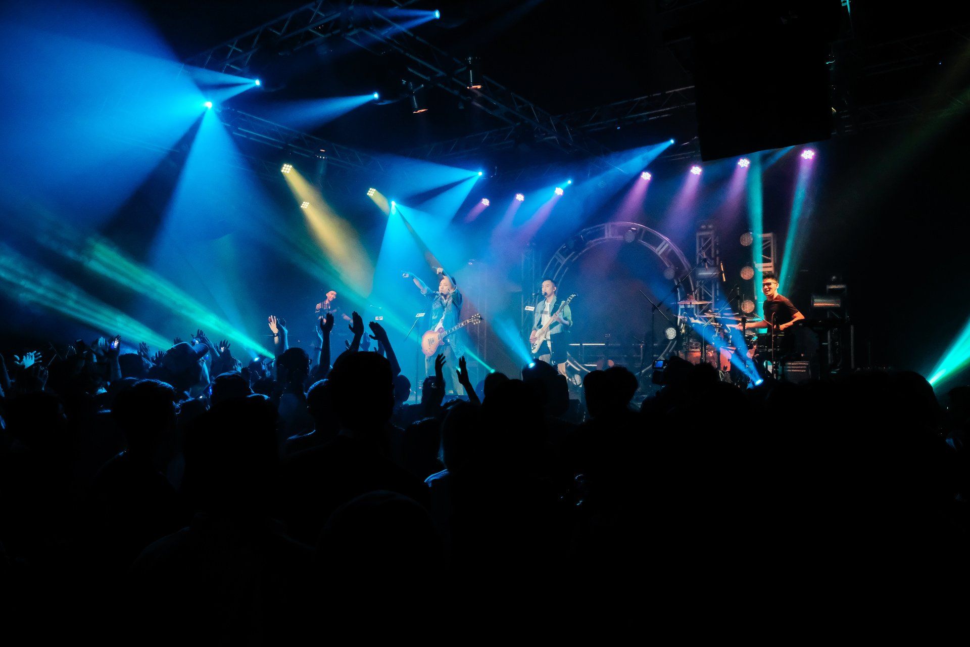 A group of people are standing in front of a stage at a concert.