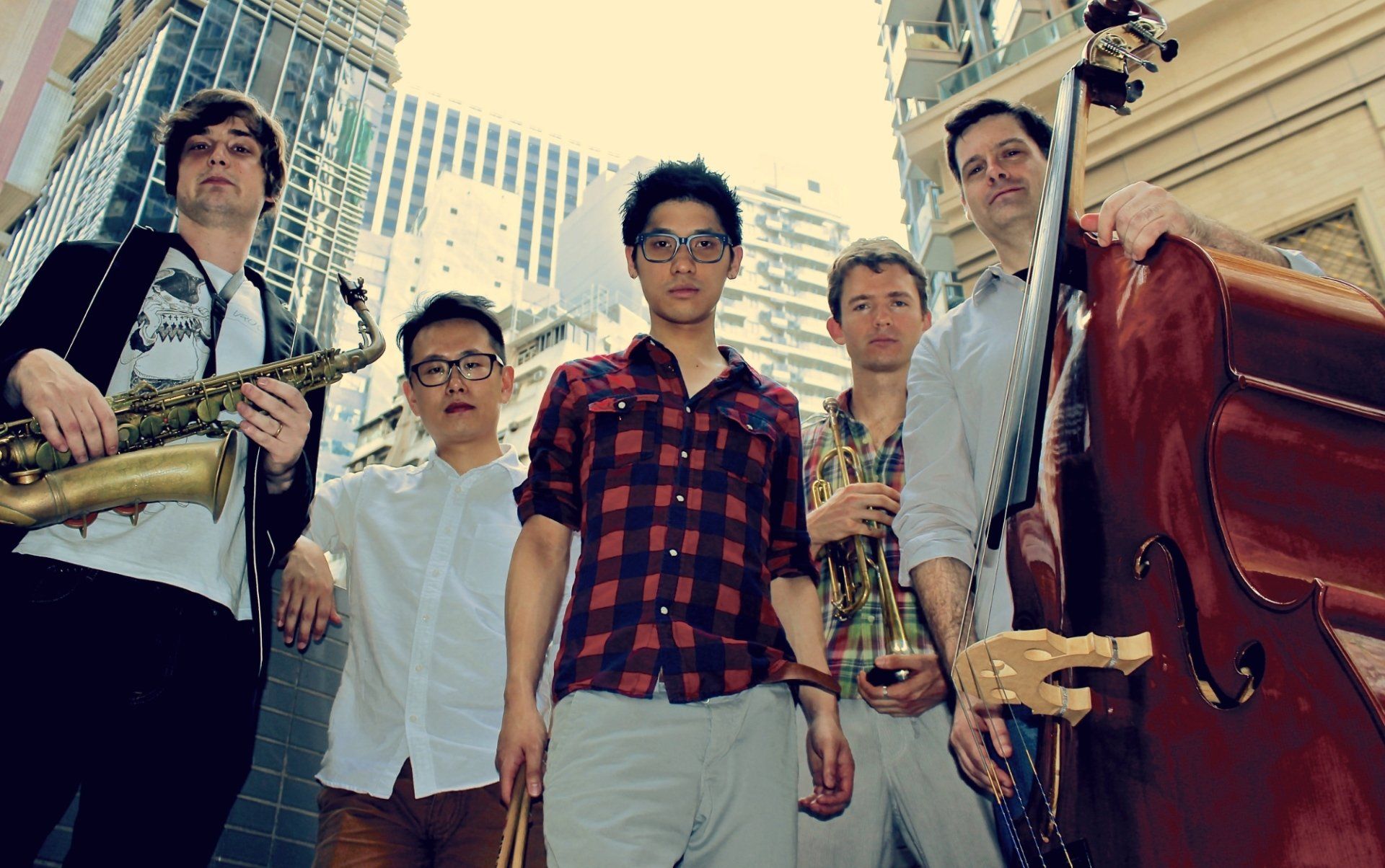 A group of young men standing next to each other holding musical instruments.