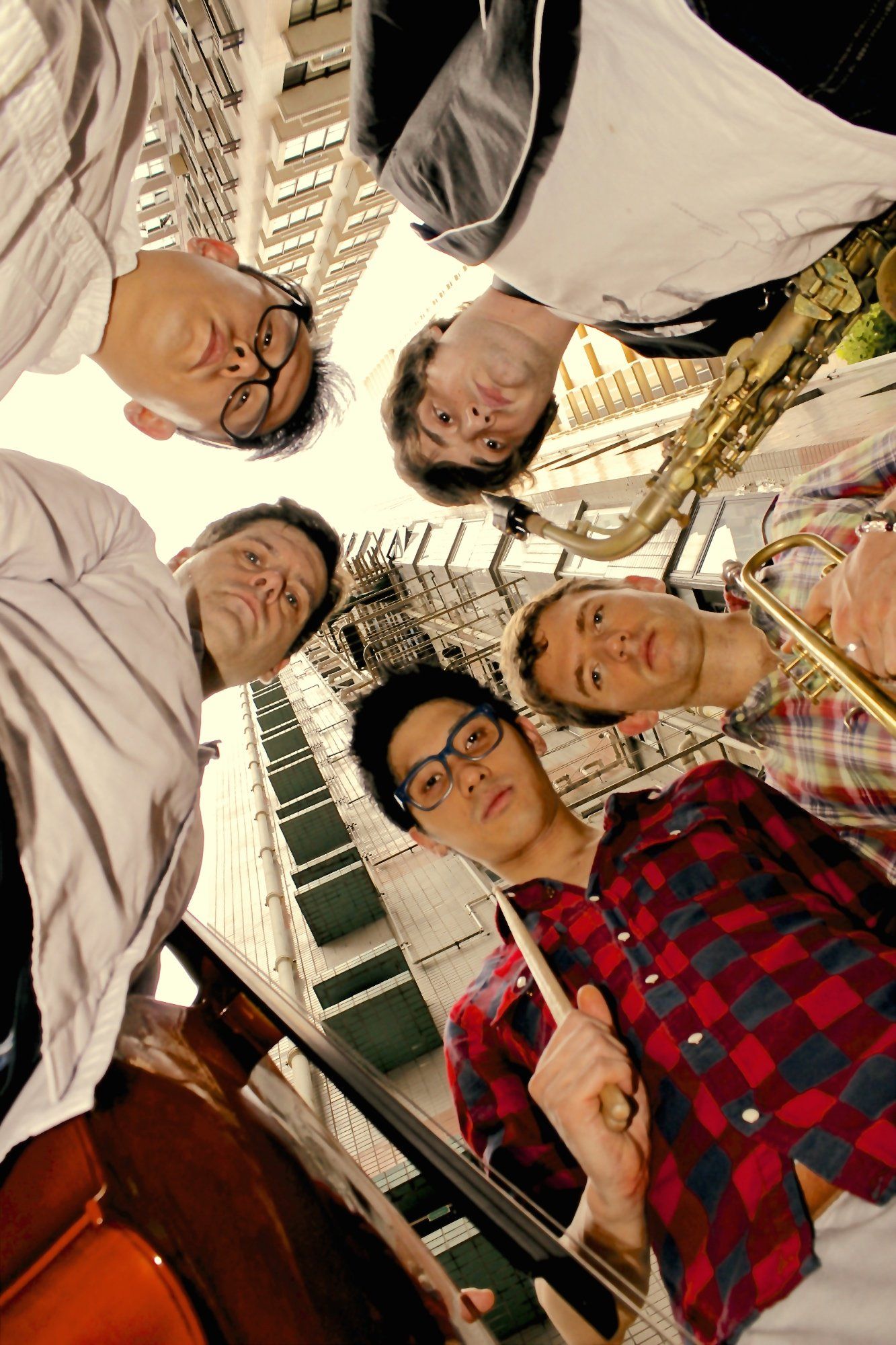 A group of men are standing in a circle holding musical instruments.