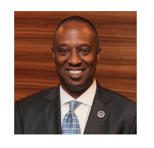 A man in a suit and tie is smiling for the camera.