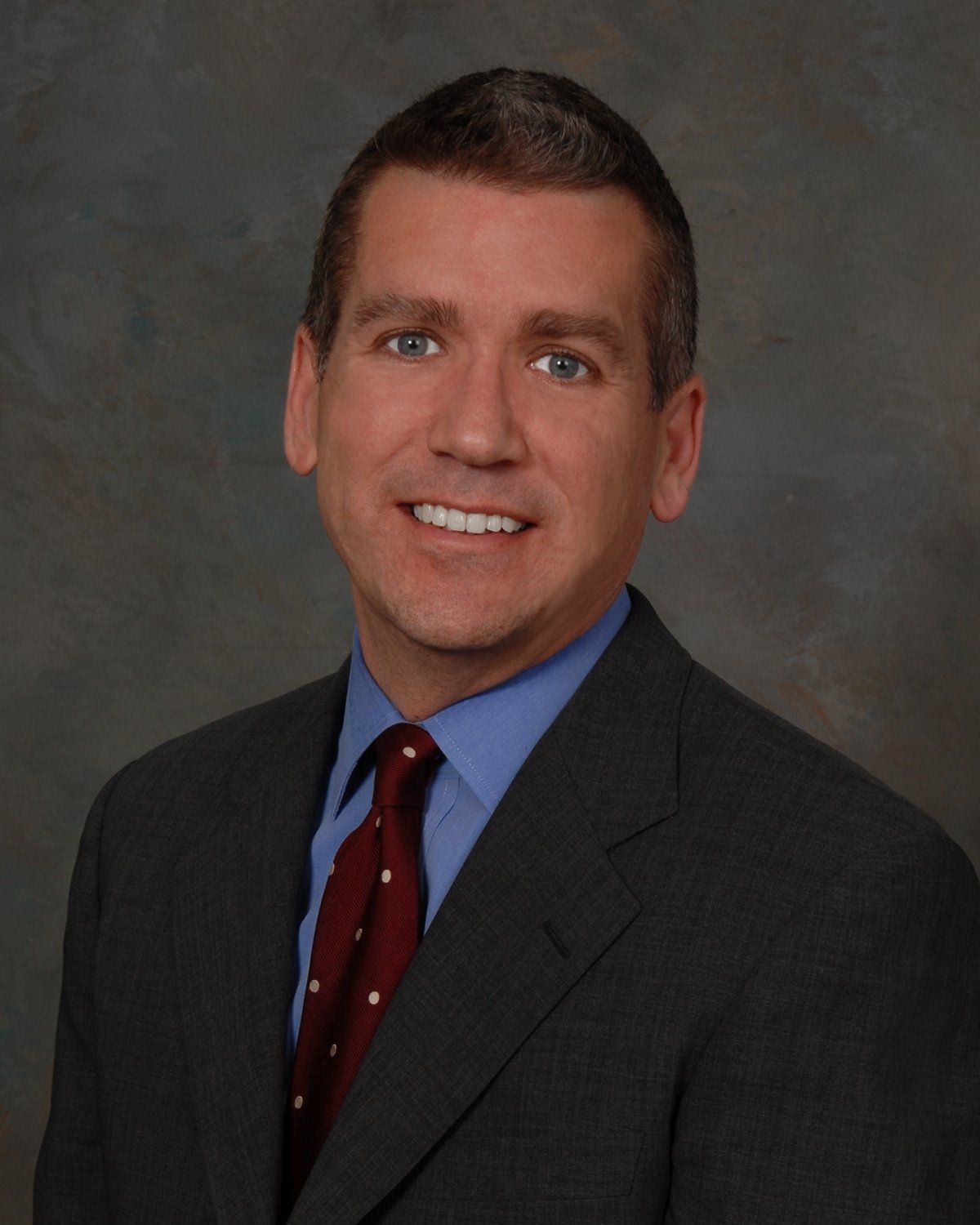 A man in a suit and tie smiles for the camera