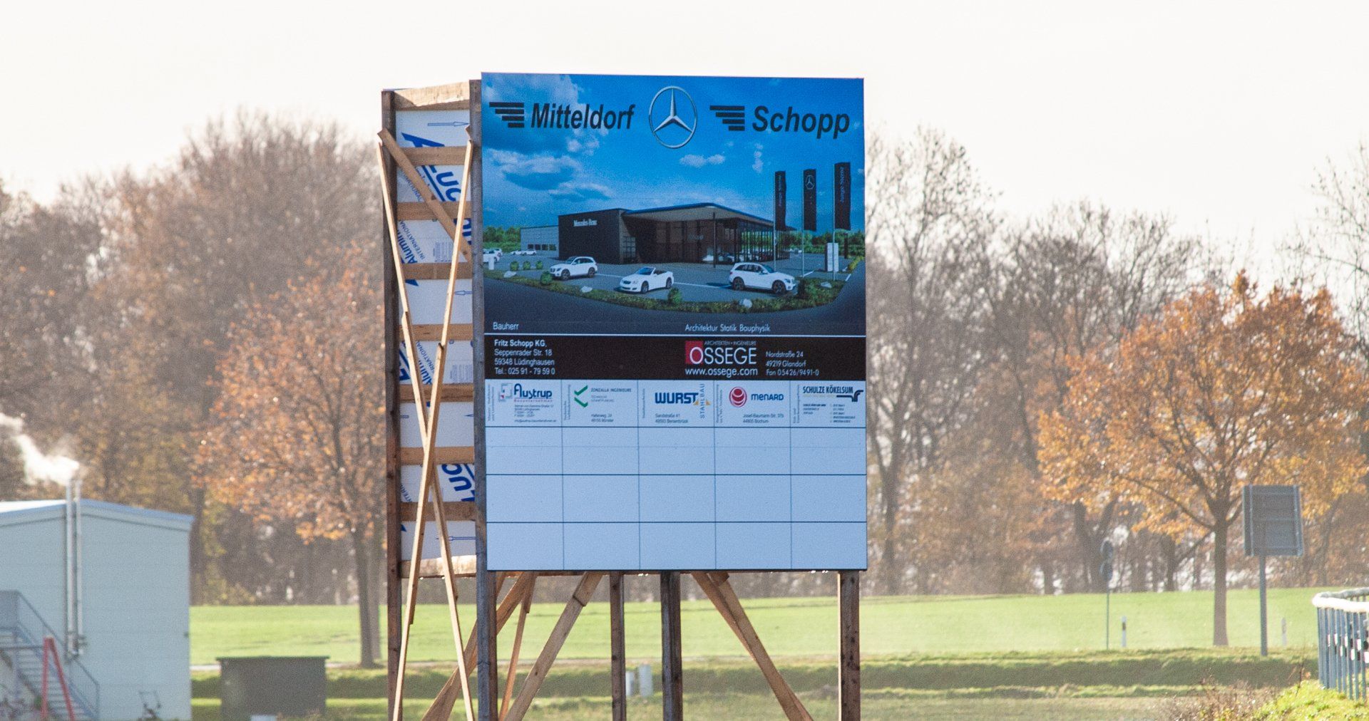 A large billboard is sitting on top of a wooden pole.