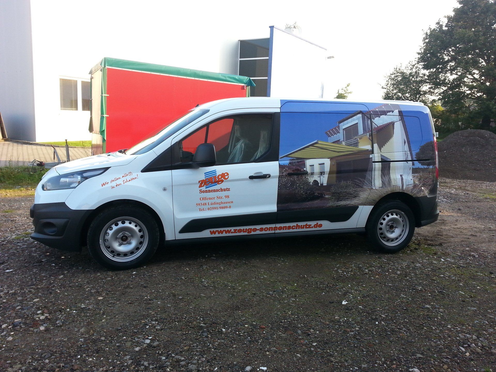 A white van has a picture of a building on the side