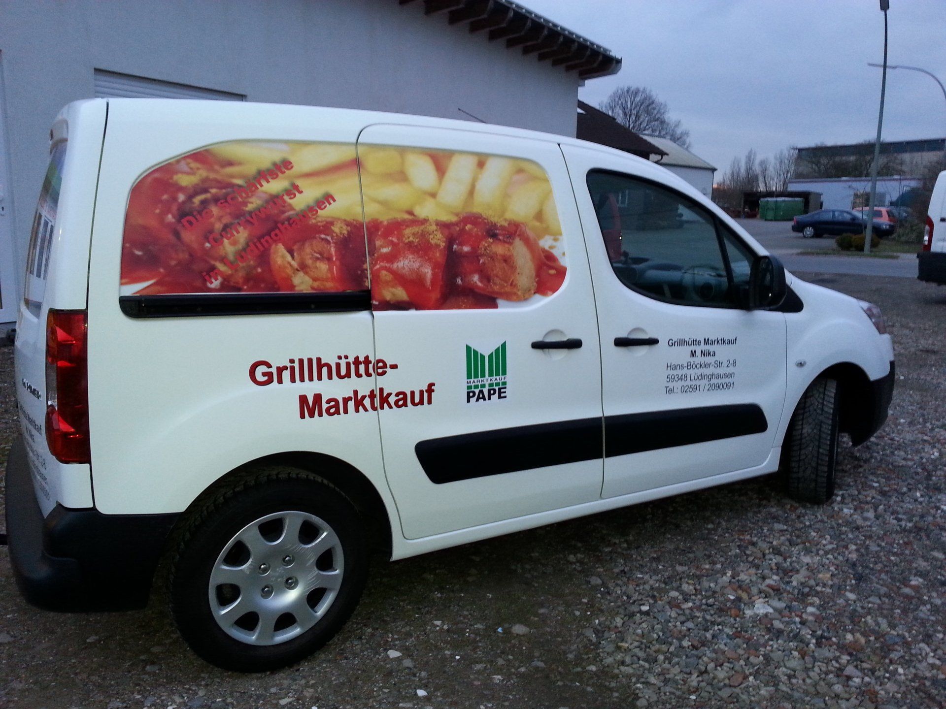 A white van has a picture of food on the side of it