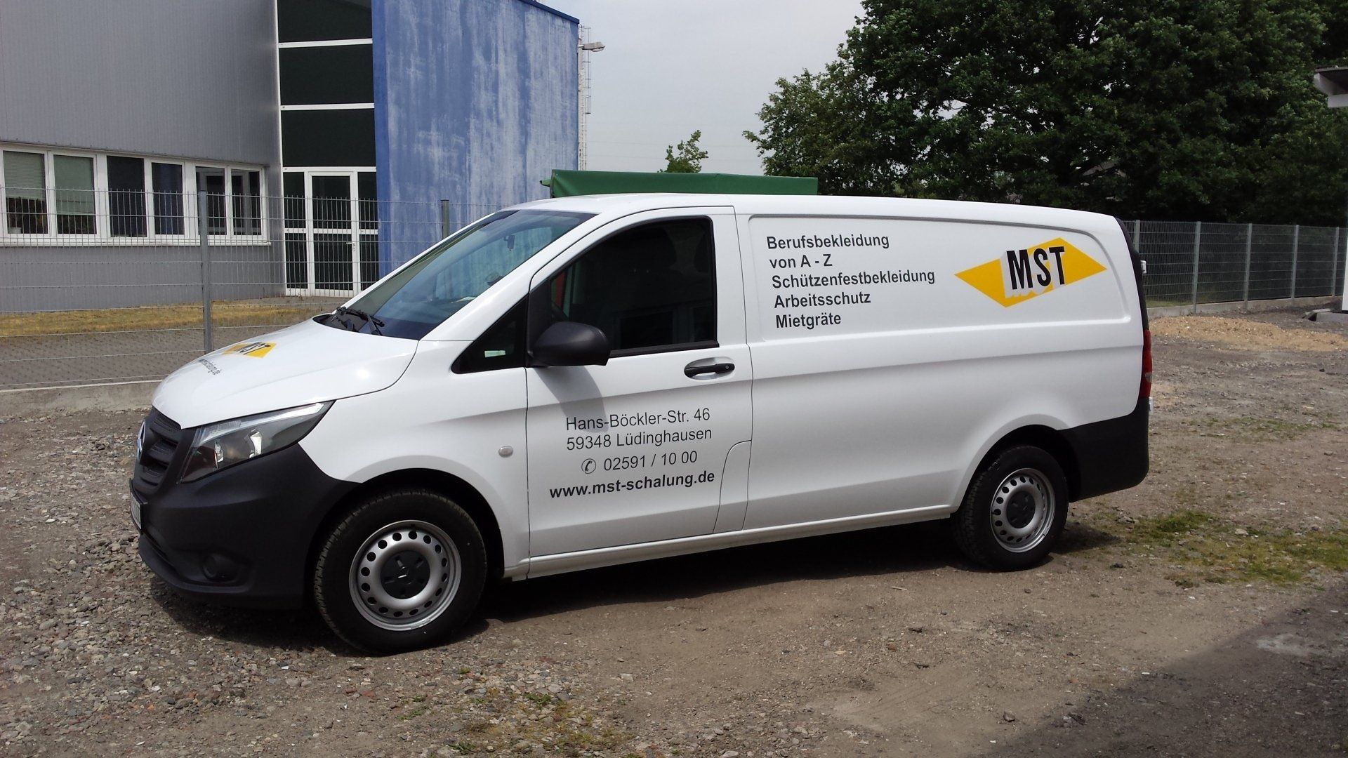 A white van with the word wst on the side is parked in a parking lot.