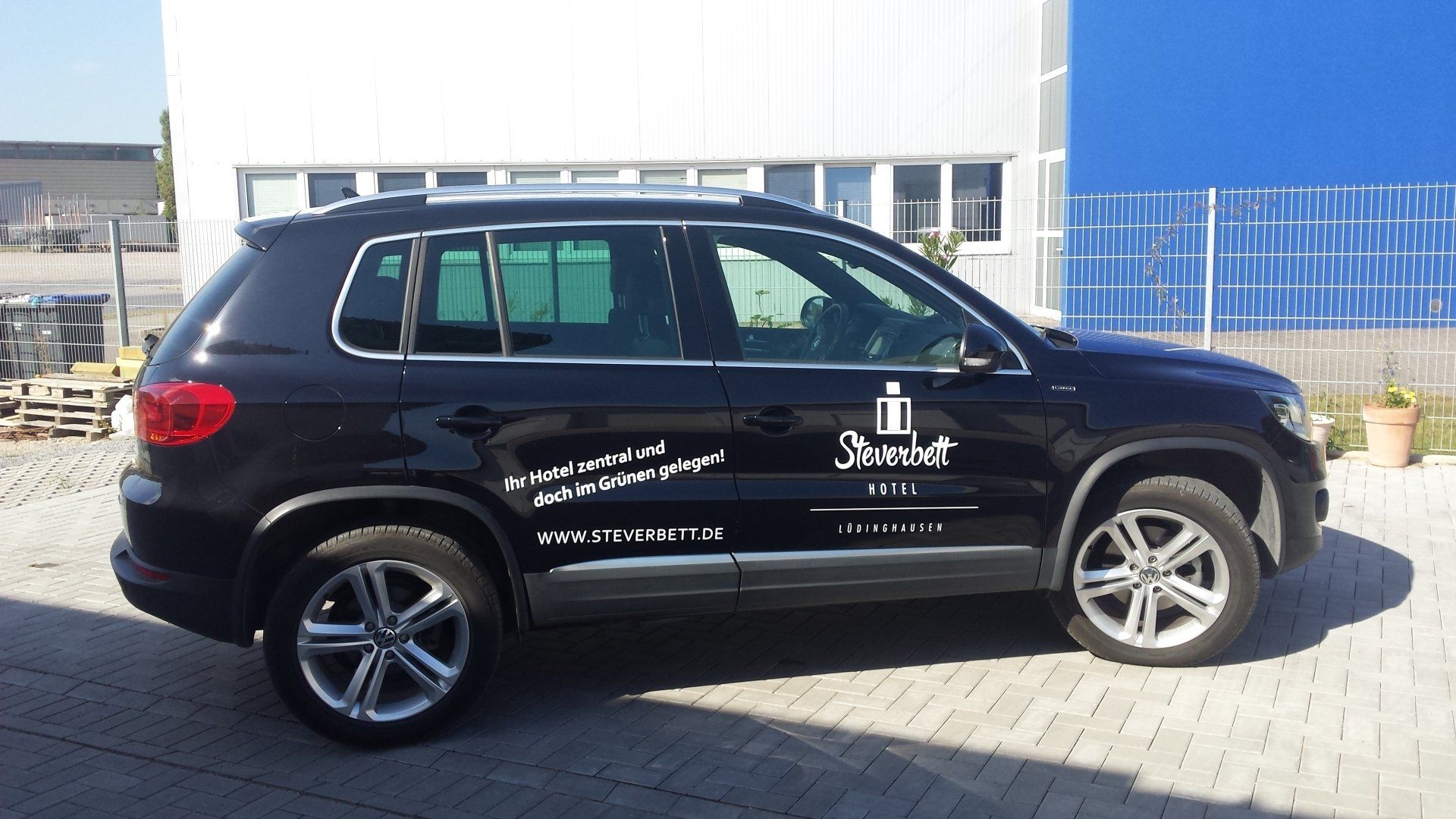A black suv is parked in front of a building