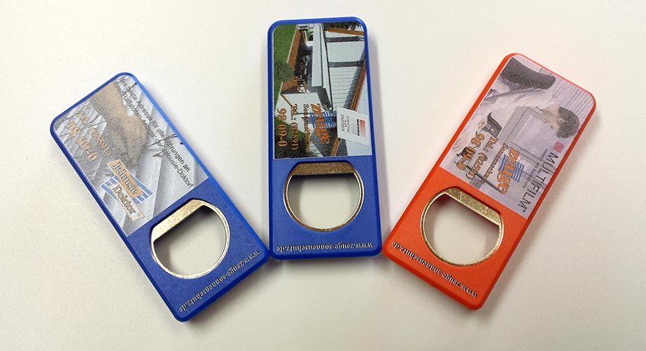 Three different colored bottle openers with pictures on them