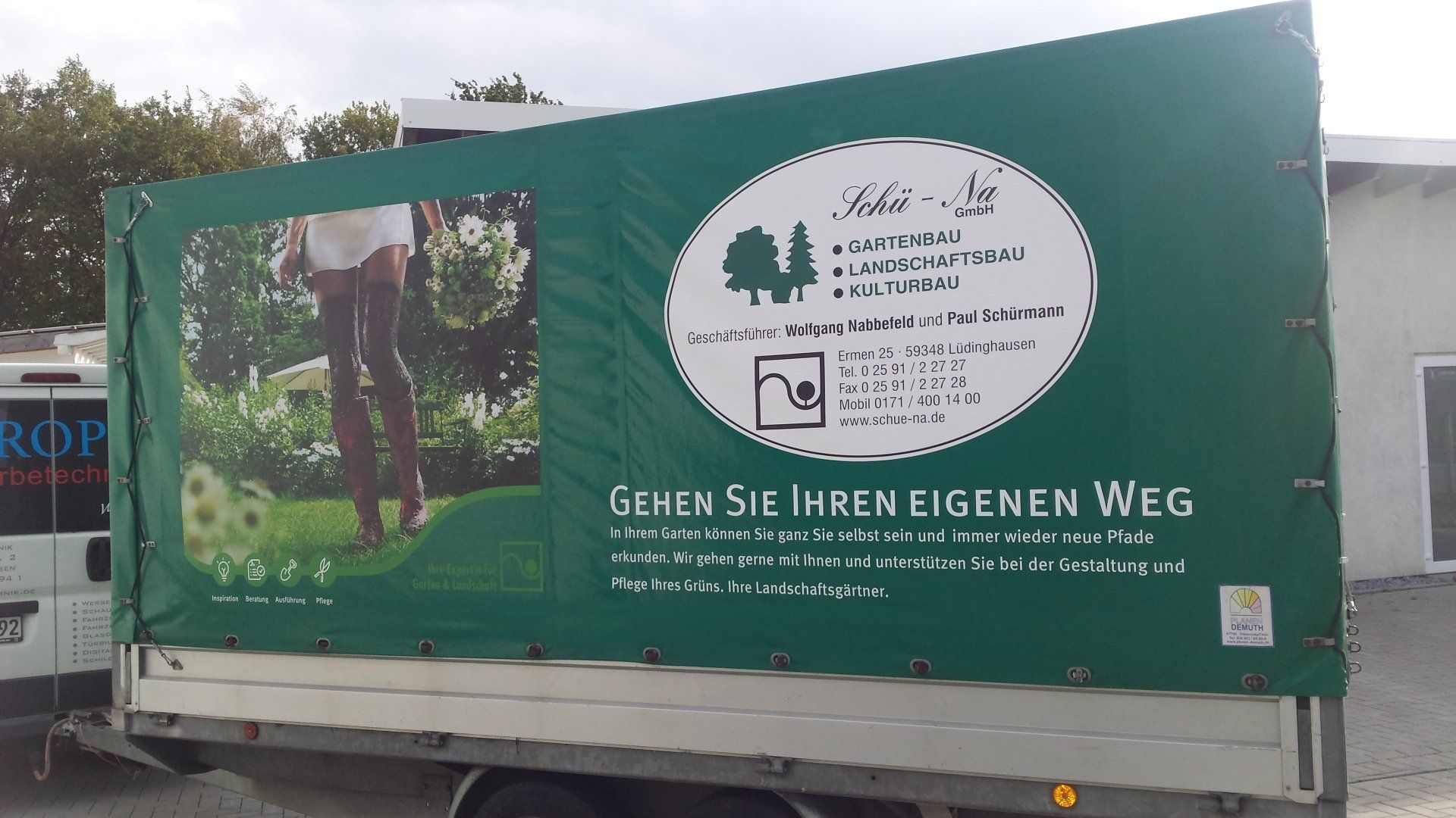 A truck with a green tarp that says gehen sie hren eigenen weg