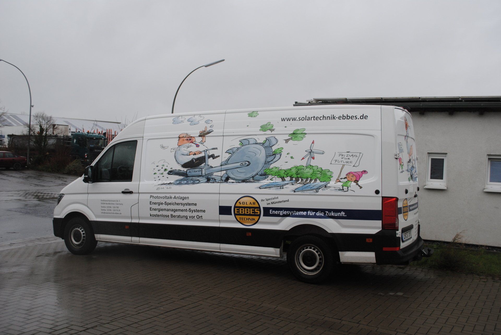 A white van is parked in front of a building