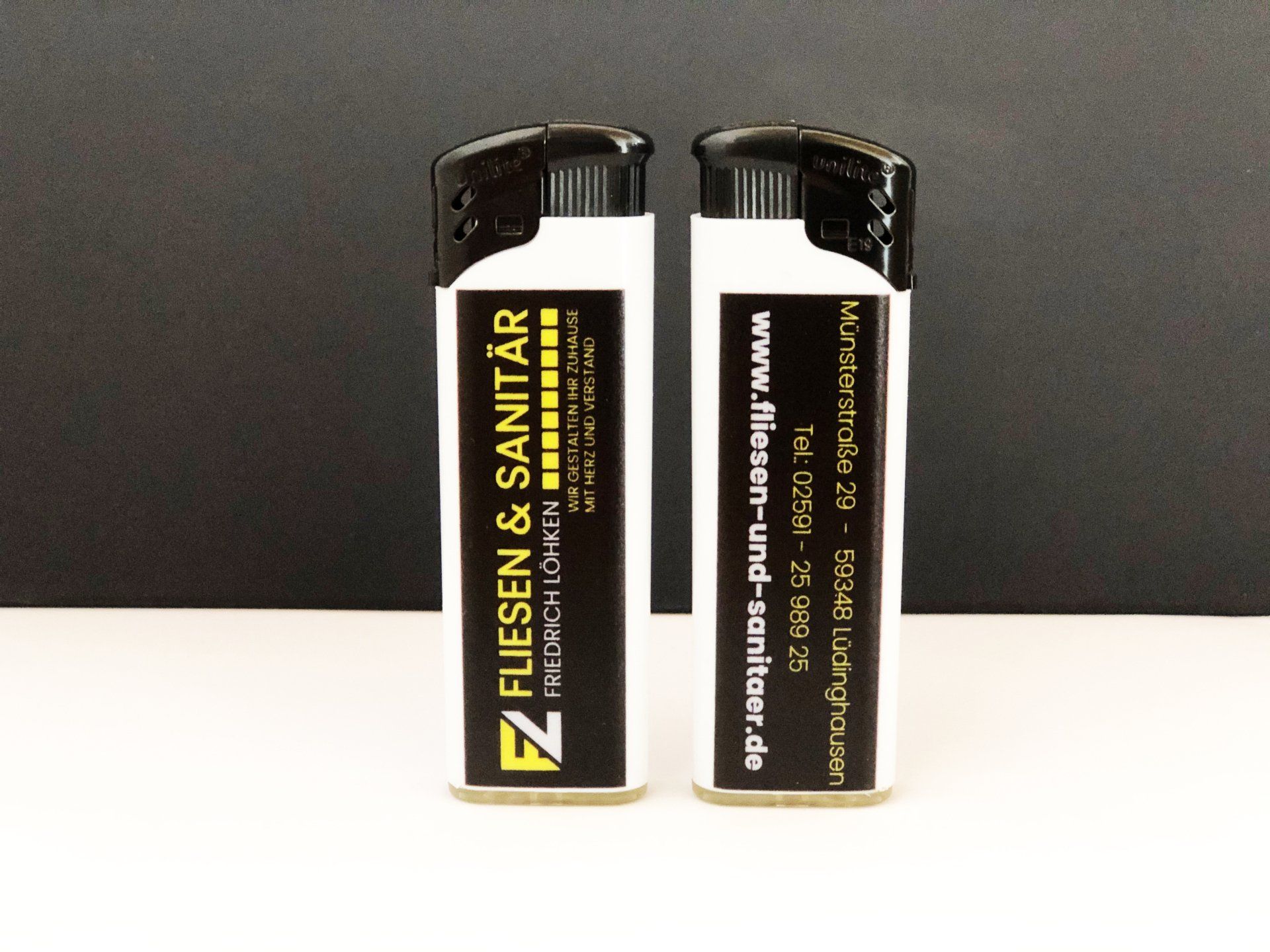 A white lighter with a black label that says fliesen & sanitar