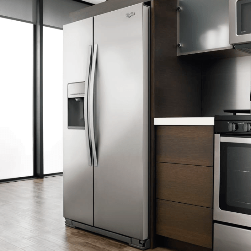 Un refrigerador de acero inoxidable en una cocina junto a una estufa.