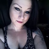 A woman in a leopard print tank top is taking a selfie.