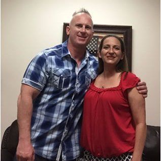 A man and a woman are posing for a picture together in a room.