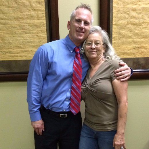 A man in a blue shirt and red tie poses with a woman
