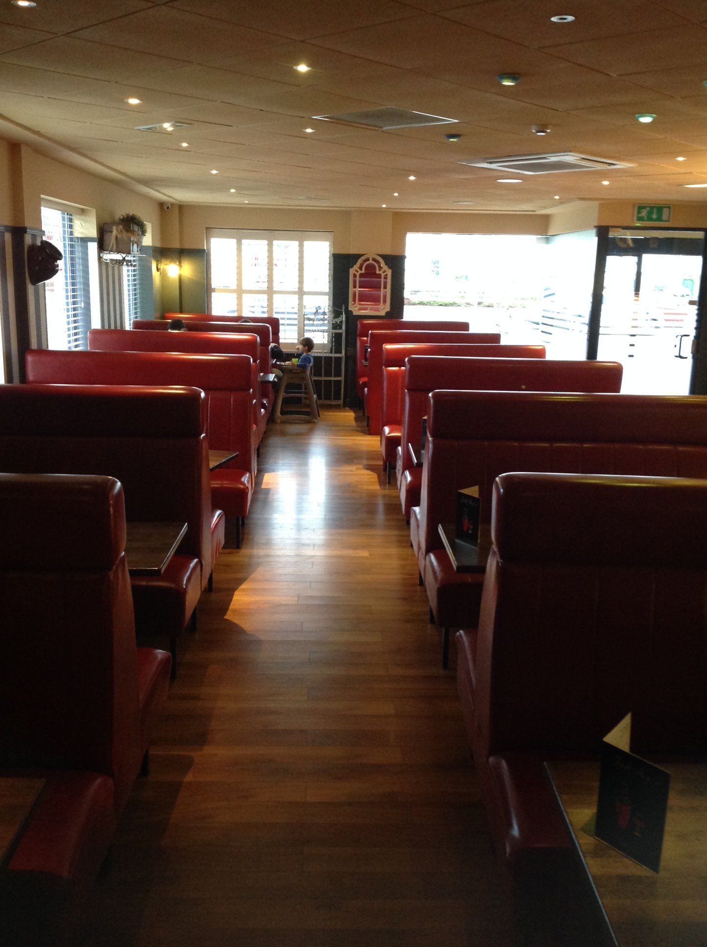 The inside of a diner with red booths and tables