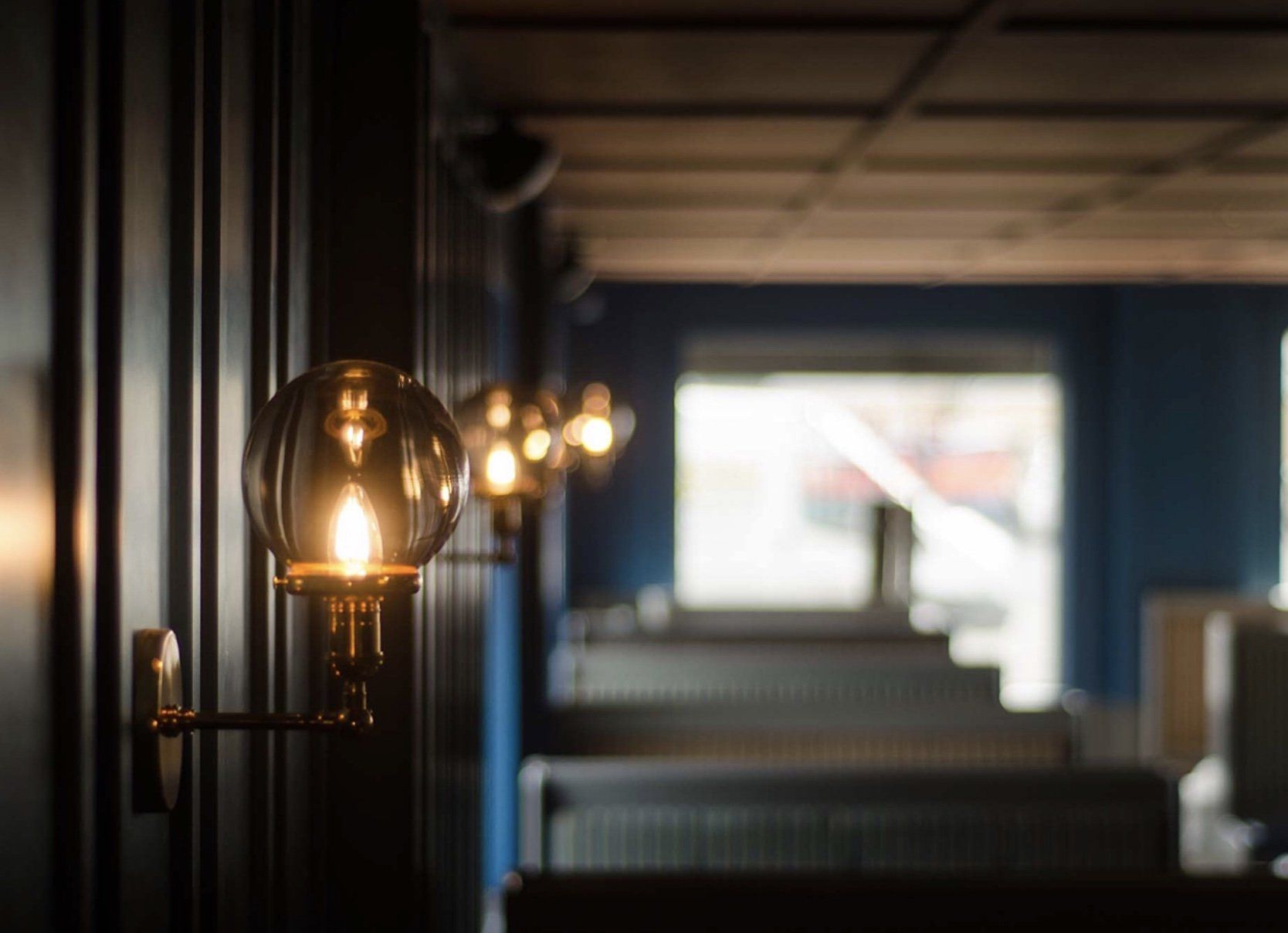 A row of lights are hanging on a wall in a dark room.