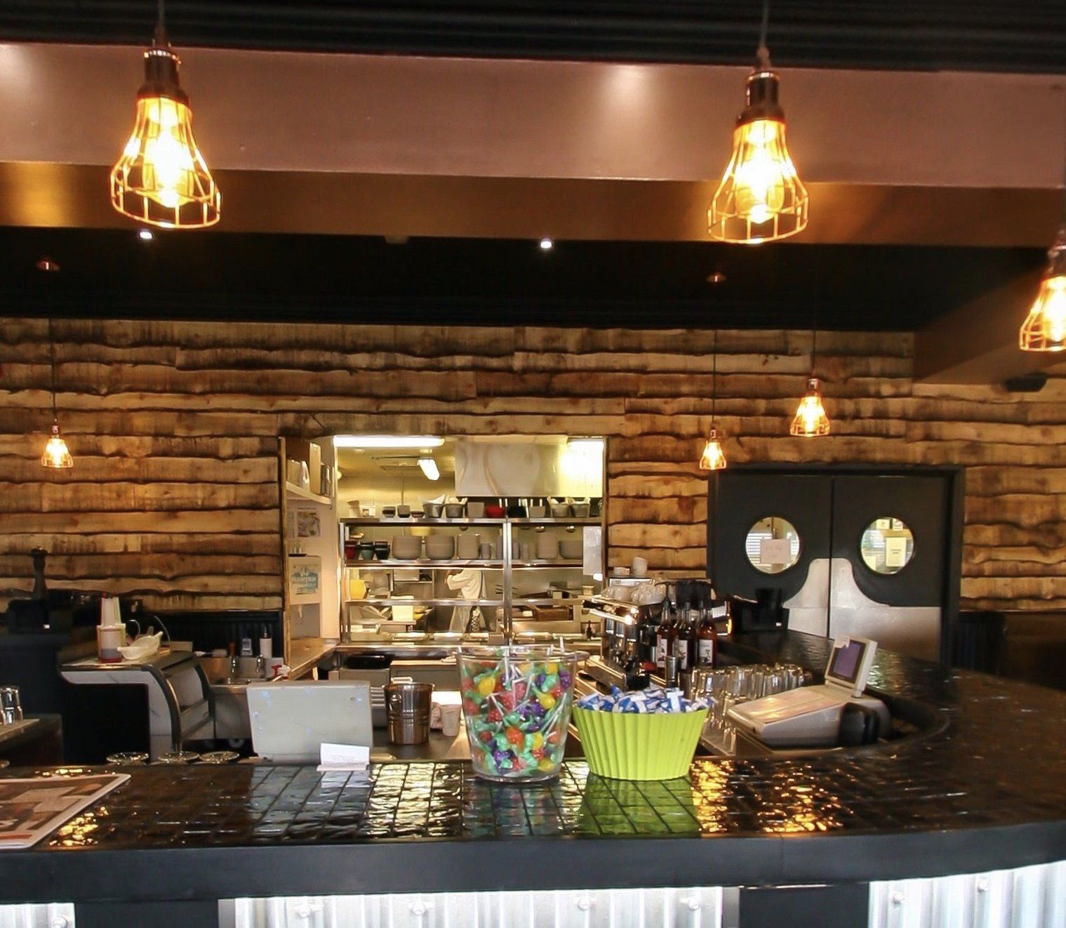A restaurant with a wooden wall and a counter