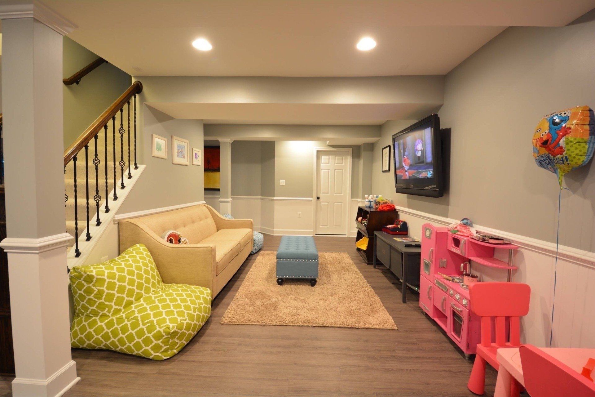 A living room with a couch , chairs , and a television.