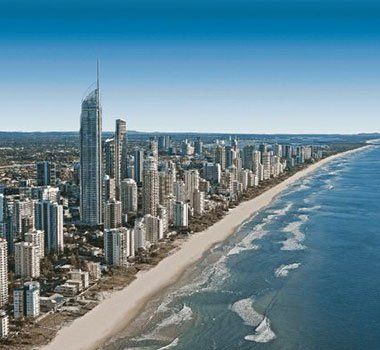 An aerial view of a city with a beach in the foreground