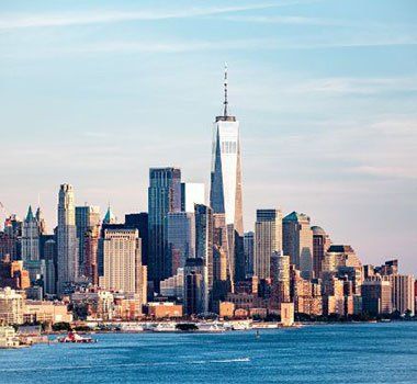 A view of the new york city skyline from across the water.
