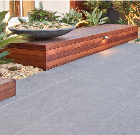 A wooden bench with a bowl of plants on top of it