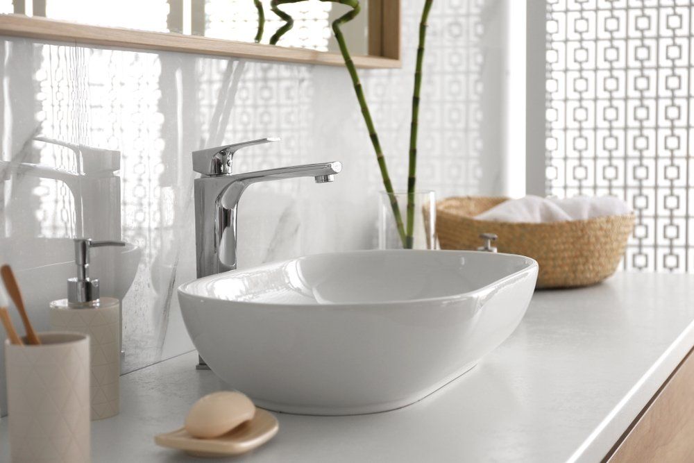 Une salle de bain avec un lavabo, du savon, des brosses à dents et un miroir.