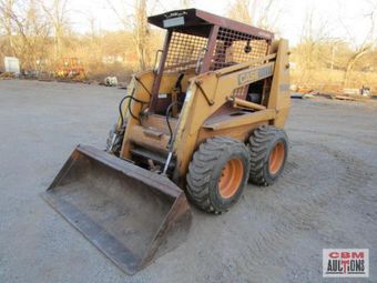 A case skid steer is parked in a dirt lot