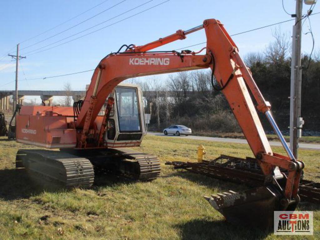 A koshaing excavator is parked in a grassy field