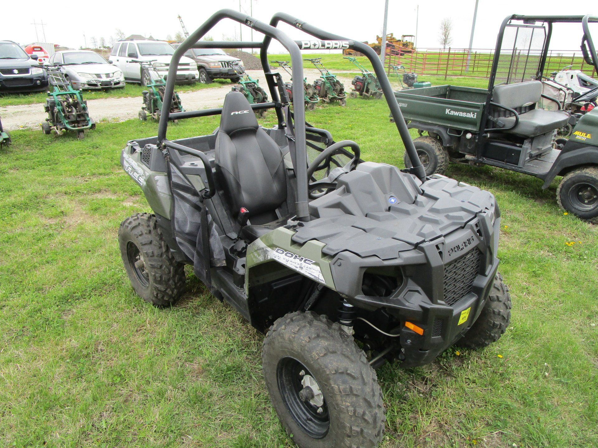 A polaris atv is parked in a grassy field.
