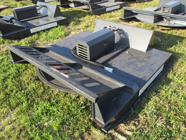 A black machine is sitting on top of a lush green field.