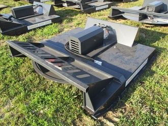 A black machine is sitting on top of a lush green field.