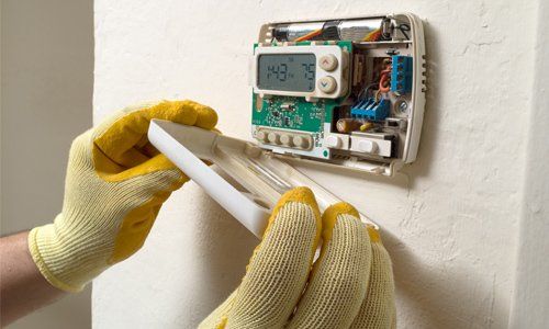 Repair man performing maintenance — Air Conditioner Repair in Pueblo, CO Repair man performing maintenance — Air Conditioner Repair in Pueblo, CO