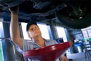 Tires — Under Car Mechanic Changing Oil in Lafayette, IN