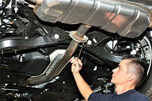 Alignment — Mechanic Working on Exhaust in Lafayette, IN Alignment — Mechanic Working on Exhaust in Lafayette, IN