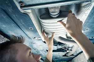 Tires — Mechanic Checking Exhaust Pipe in Lafayette, IN Tires — Mechanic Checking Exhaust Pipe in Lafayette, IN