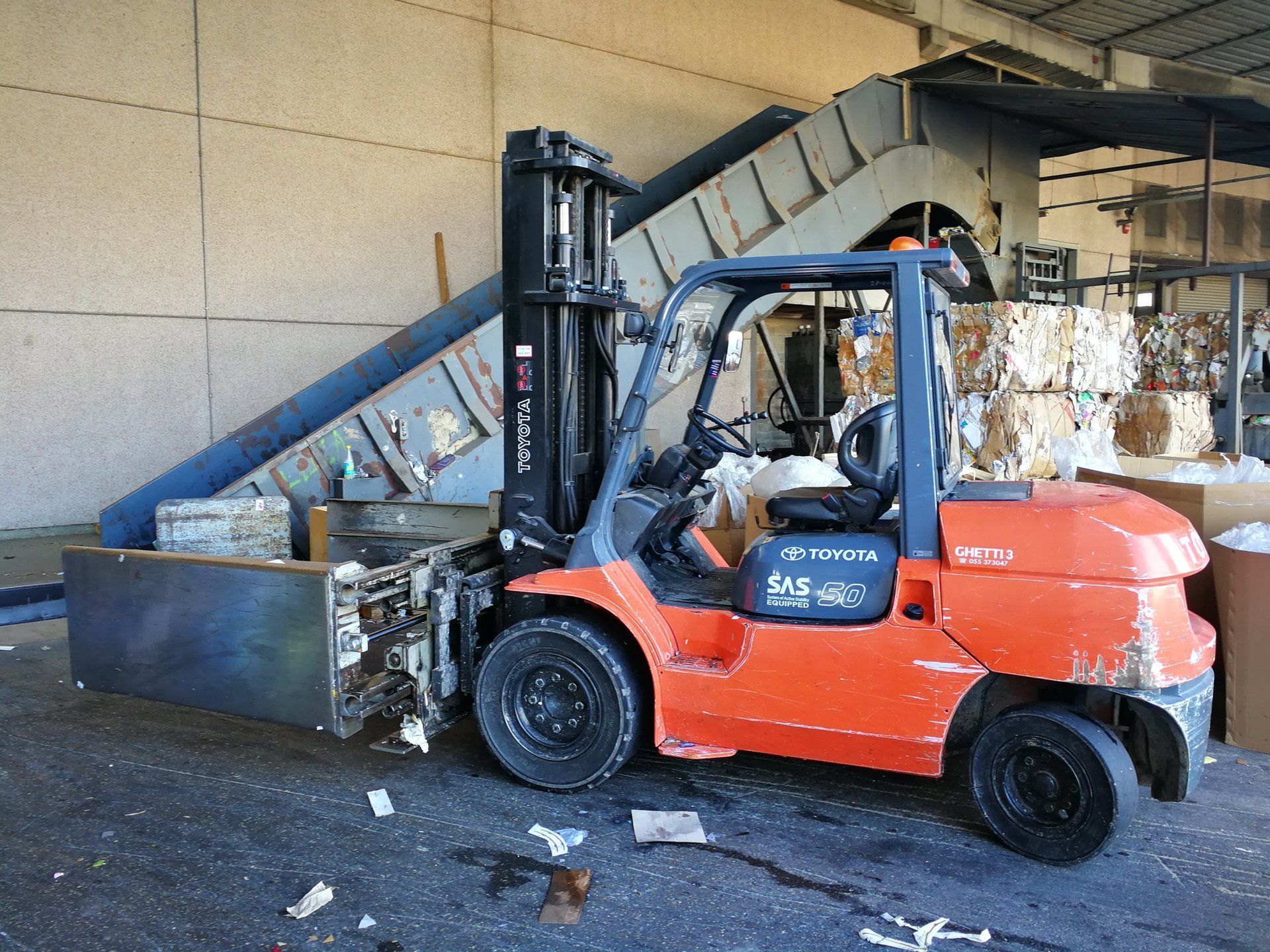 operatore su muletto mentre trasporta carta da smaltire