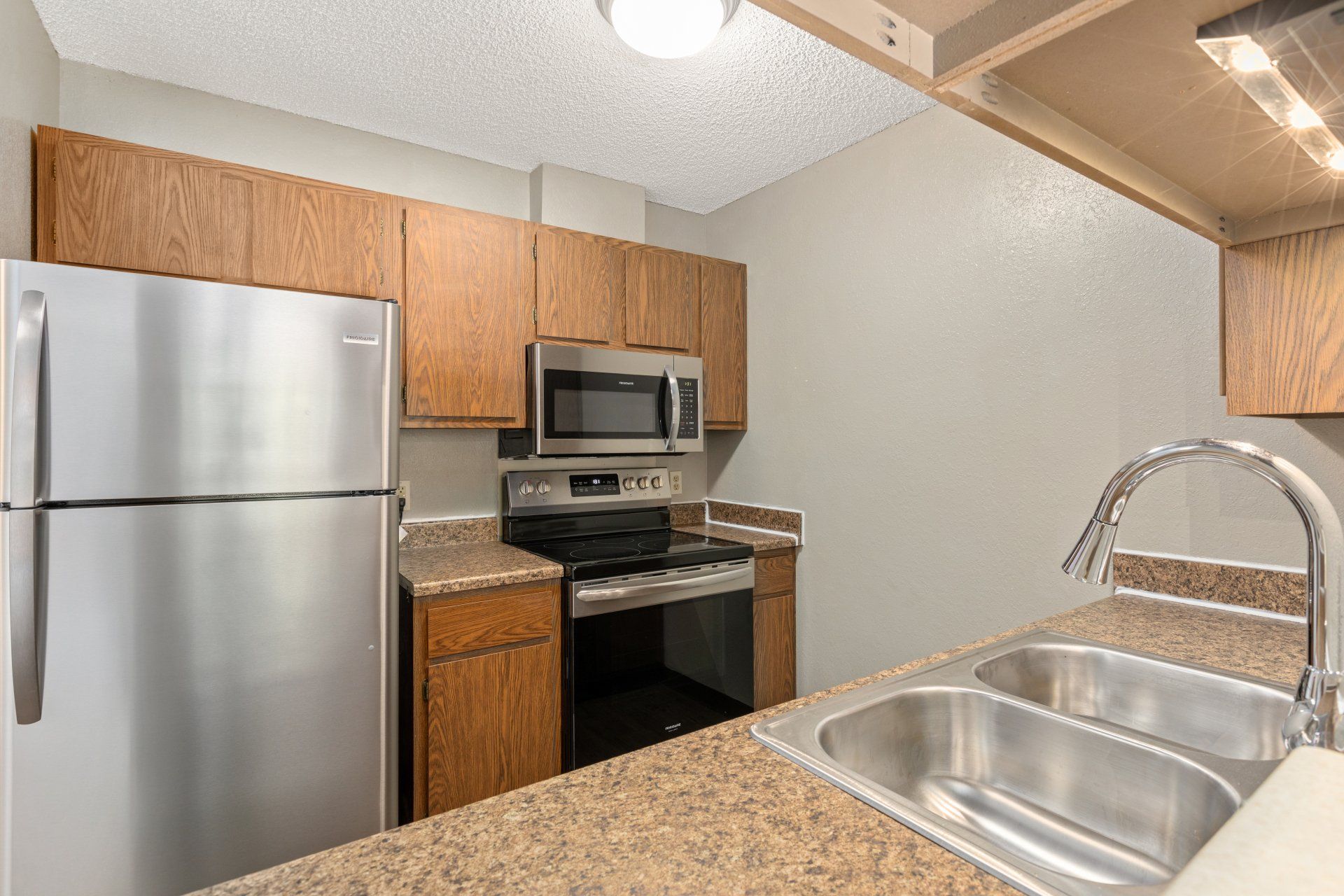 Kitchen with wood cabinetry, stainless steel appliances, and dishwasher