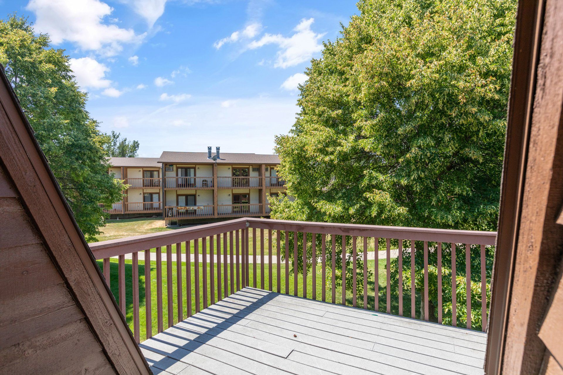 View from deck exterior overlooking the grass field and walkway