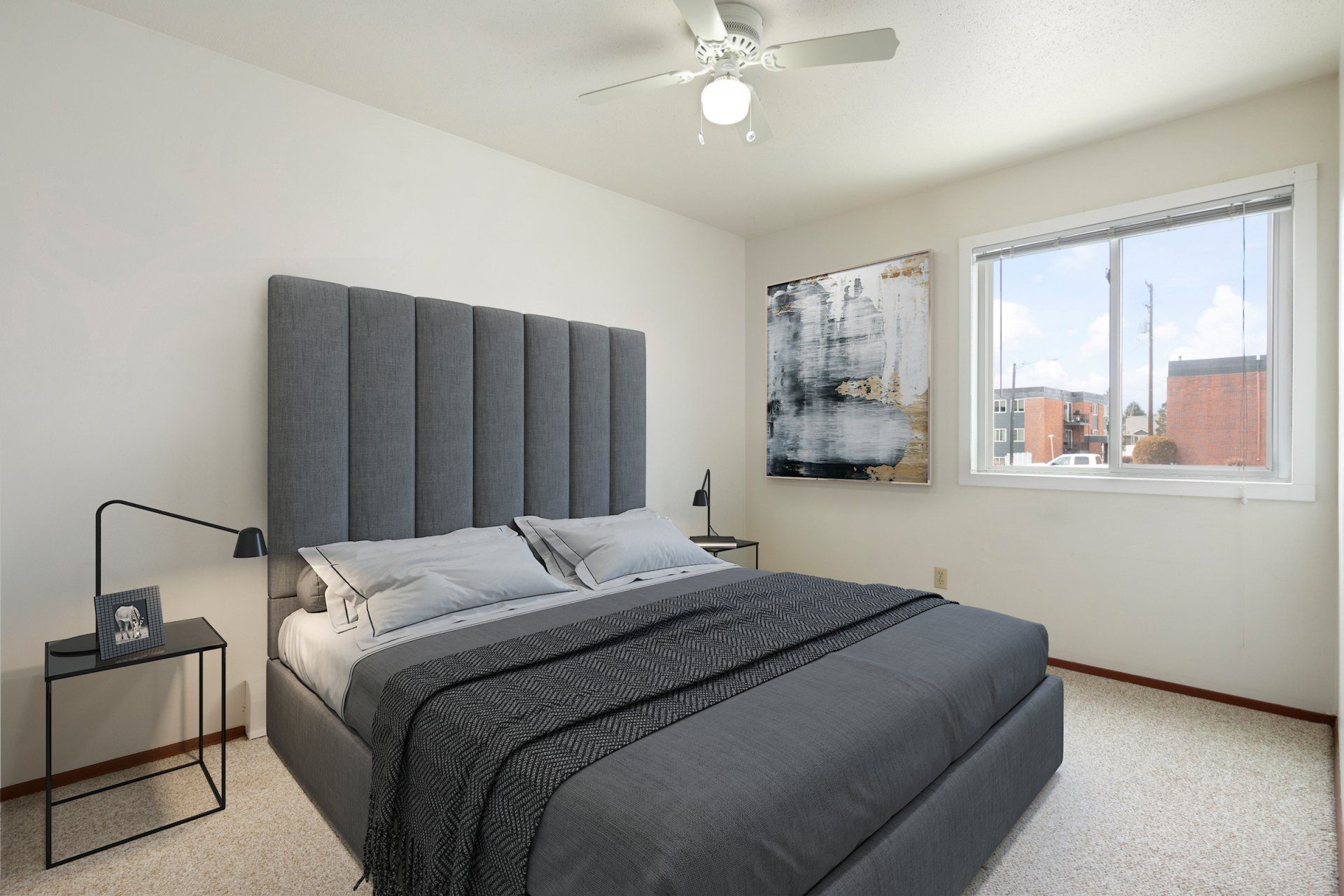 Large bedroom with ceiling fan, large window, and white walls