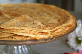 Une pile de crêpes sur une plaque de verre sur une table.
