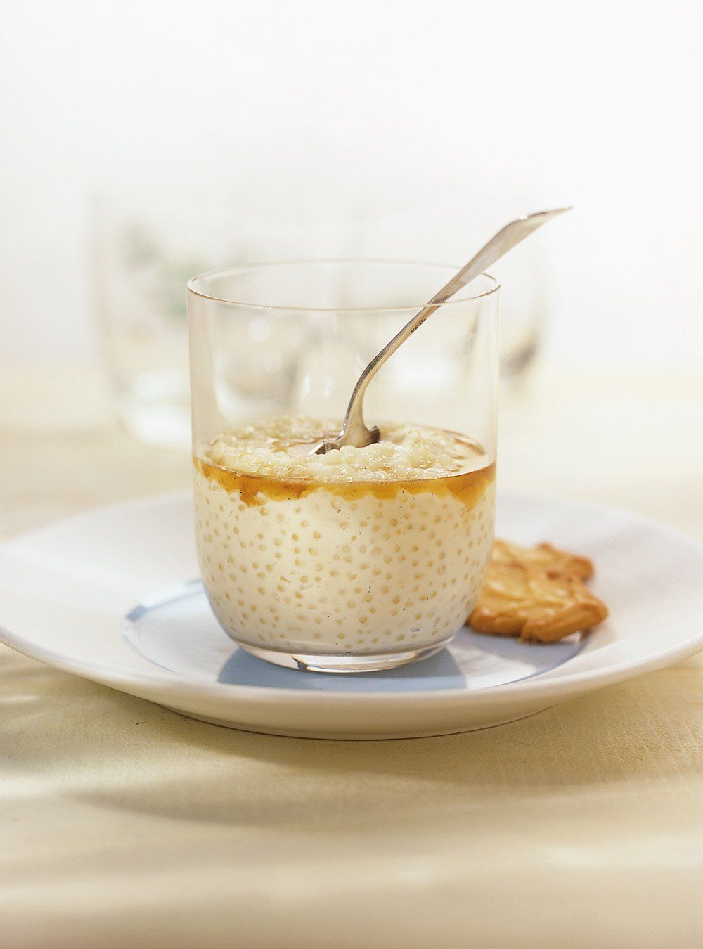 Un verre de soupe avec une cuillère dedans sur une assiette