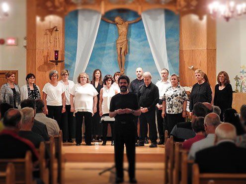 Un homme se tient devant une chorale dans une église.