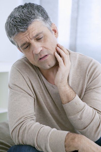 A man having tooth pain - wisdom teeth extractions tuscaloosa al